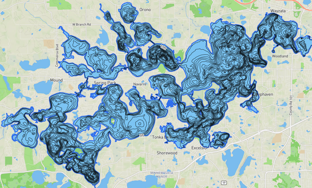 A full-lake depth contour map of Lake Minnetonka overlaid on a road map, showing the sprawling, many-armed shape of the lake's bays around Orono, Wayzata, Mound, Spring Park, Navarre, Deephaven, Excelsior, Shorewood, and Tonka Bay.